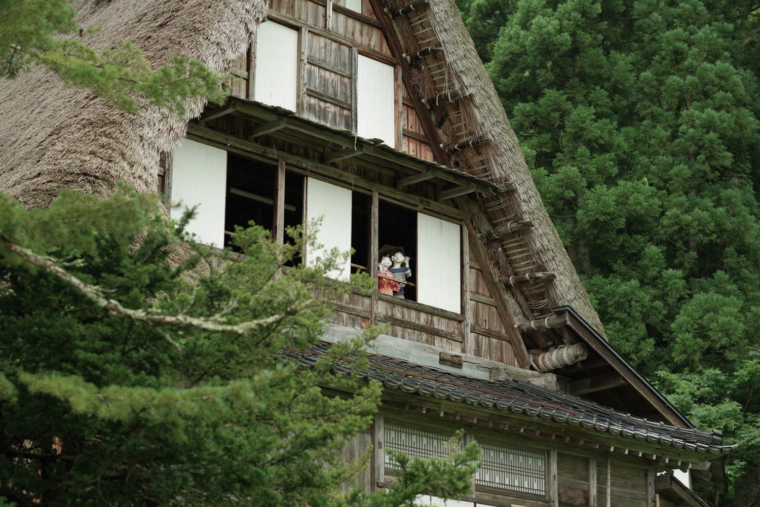 合掌造りの家から見下ろす子供の人形（相倉集落）の写真素材