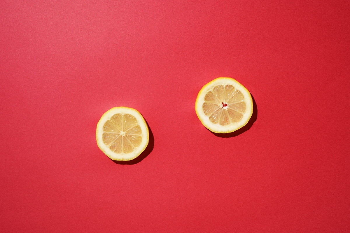 赤い背景とレモンの輪切りの写真素材