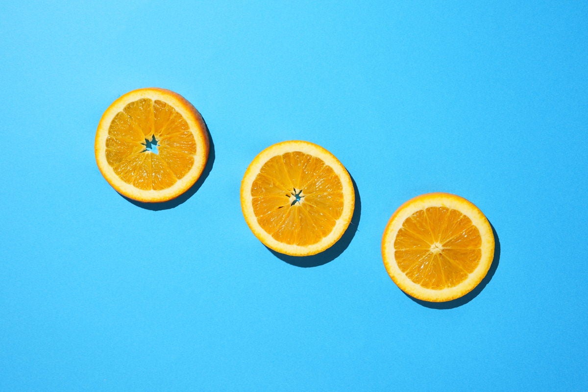 青色の背景と輪切りオレンジの写真素材