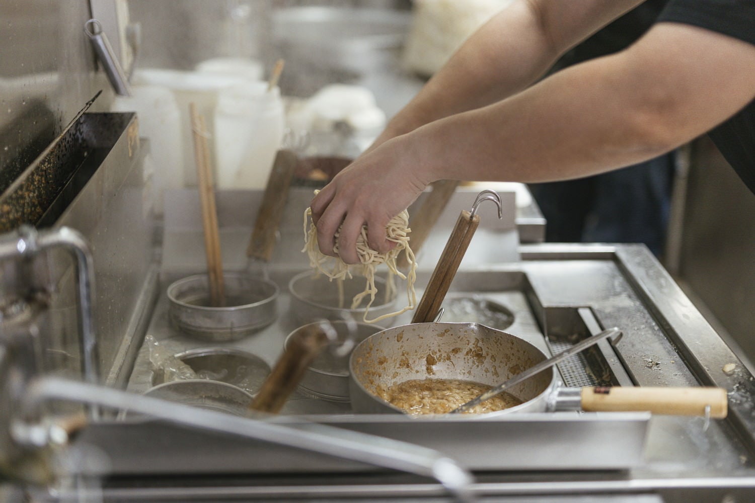 麺茹機のテボに麺を入れていく様子の写真素材