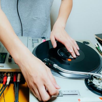 ターンテーブルを操作するDJの手元の写真