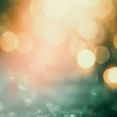 緑と暖色の光が溶け合う玉ボケの写真