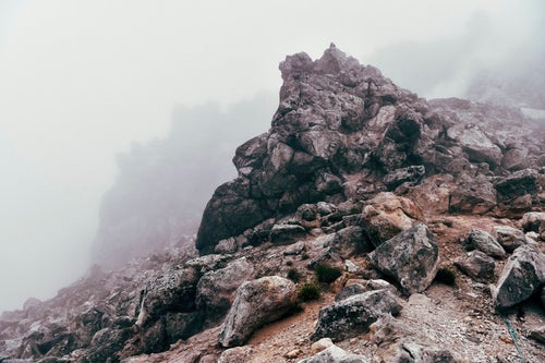 ガスに包まれる焼岳山頂の巨大な岩の写真