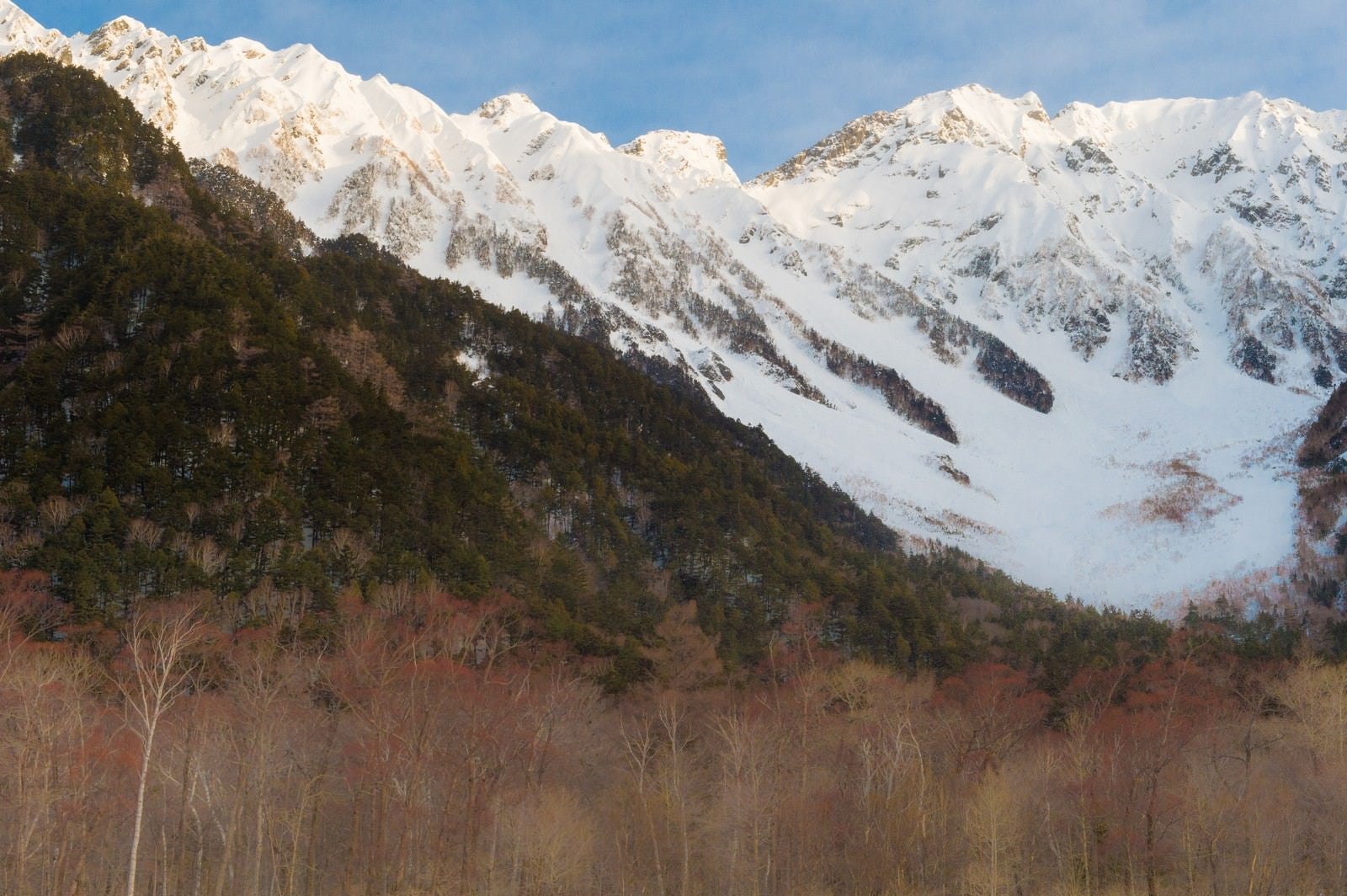 「冬の上高地の透き通った空気の先にある穂高連峰」の写真