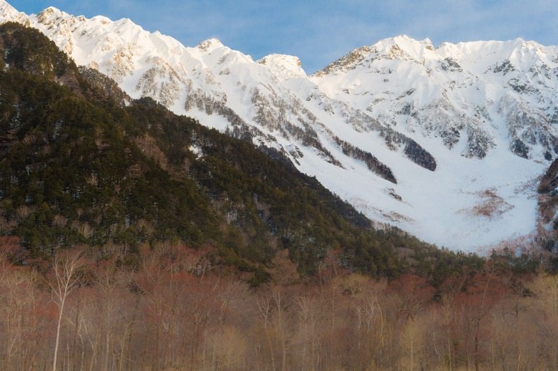 冬の上高地の透き通った空気の先にある穂高連峰の写真