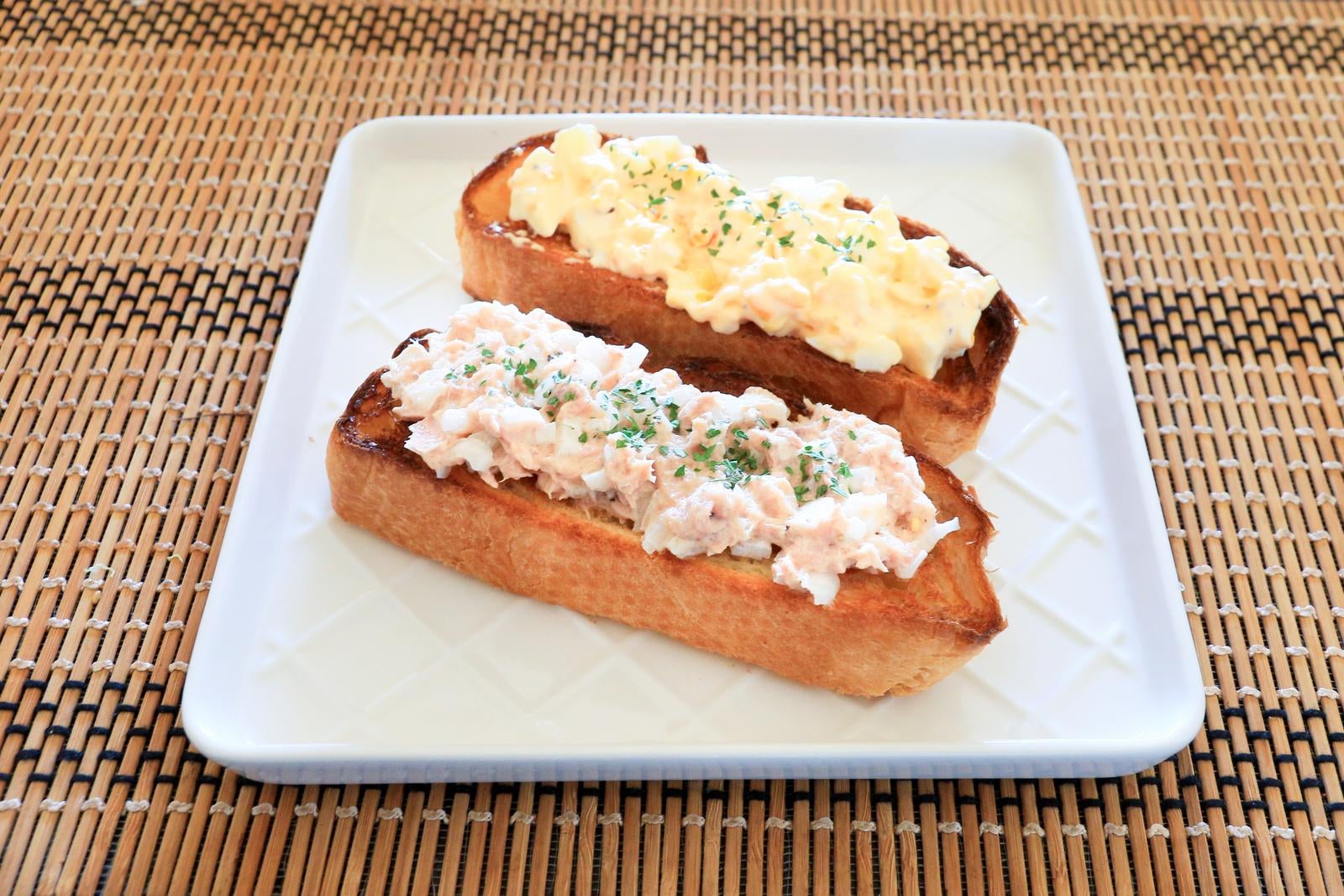 白い皿に盛られたツナマヨとたまごマヨのオープンサンド2本