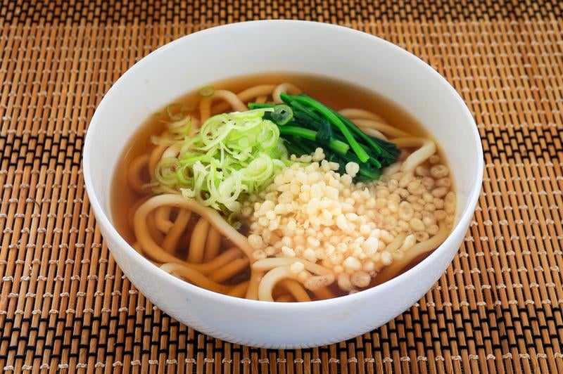 ねぎと天かすをのせたかけうどんの写真