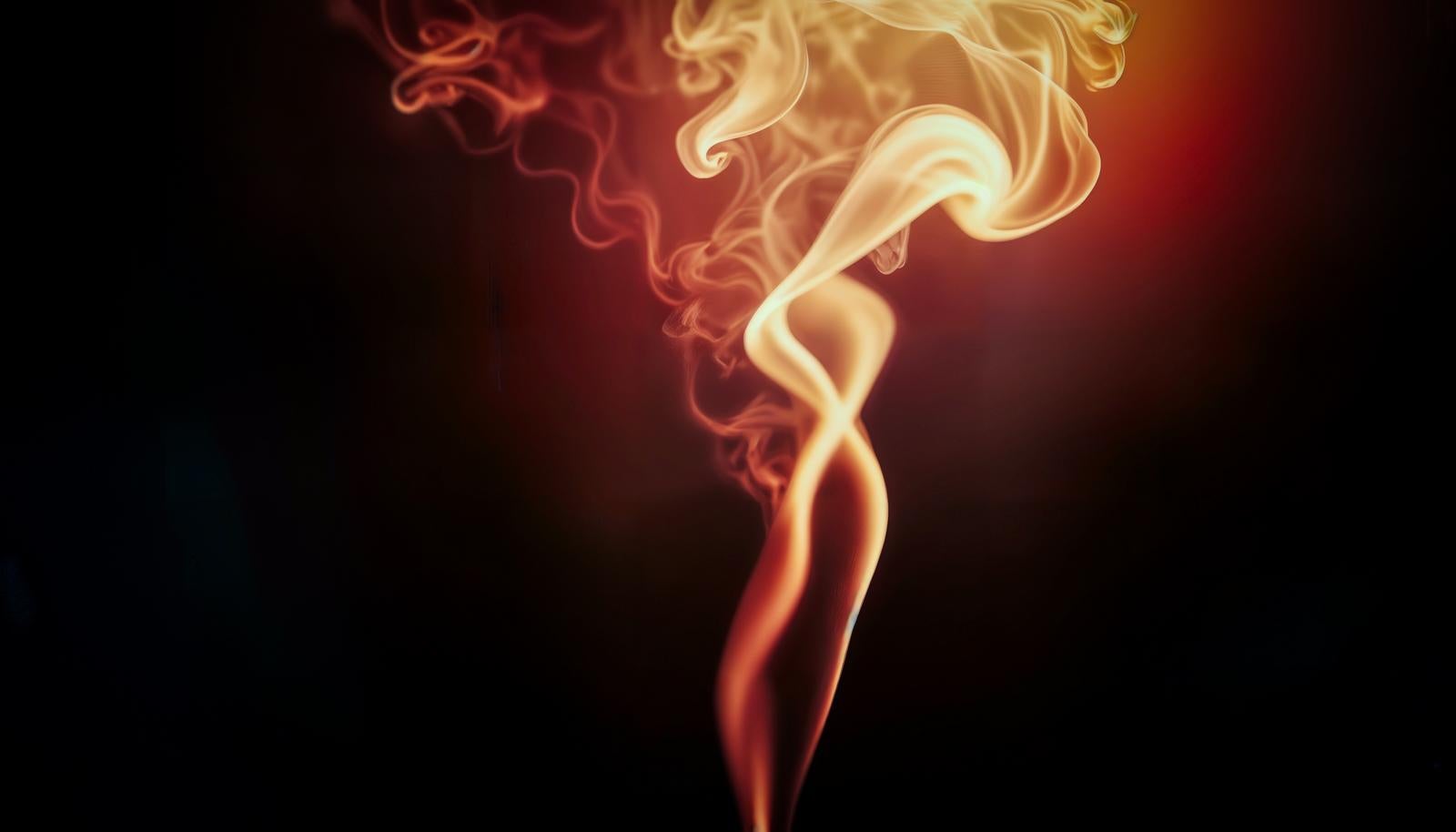 Orange smoke rising upward in complex shapes against a black background, flowing from bottom to top
