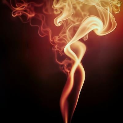 黒背景に立ち上るオレンジ色の煙の写真