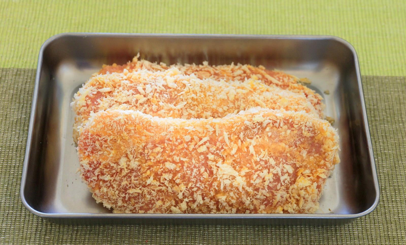 ステンレスバットに載ったパン粉をまぶした揚げる前のとんかつ2枚