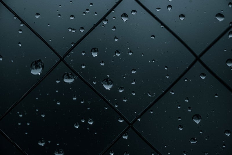 薄暗い窓と水滴の写真