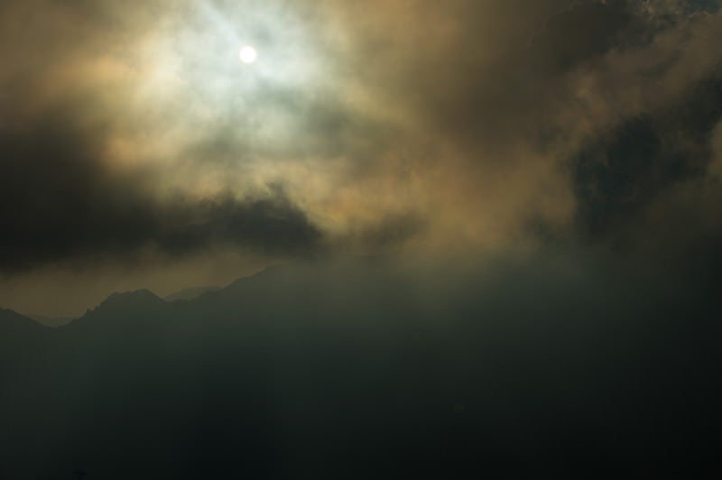 北アルプスの曇天の中登山道を照らす満月の写真