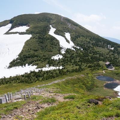 残雪の八甲田大岳と山小屋の写真