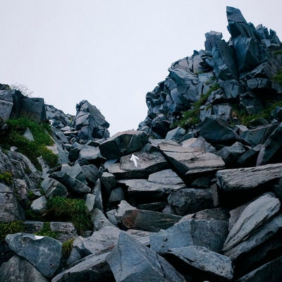 曇り空の下の鳥海山山頂の岩場の写真
