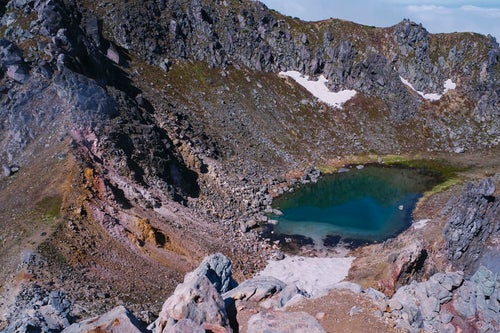 初夏の焼岳山頂の火山湖の写真