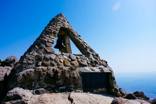 晴天の空のもとの岩木山山頂の碑の写真