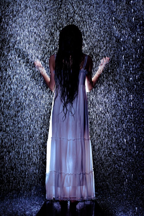 雨に打たれる女性の後姿の写真