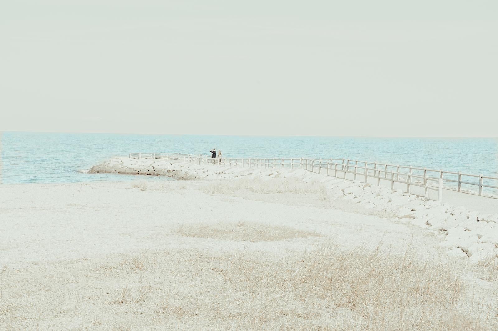「伊勢市二見興玉神社から望むカップルが見守る海辺と水平線」の写真