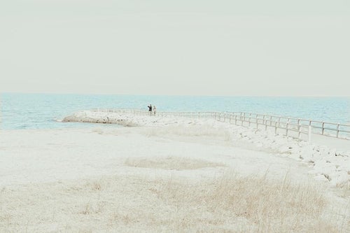 伊勢市二見興玉神社から望むカップルが見守る海辺と水平線の写真