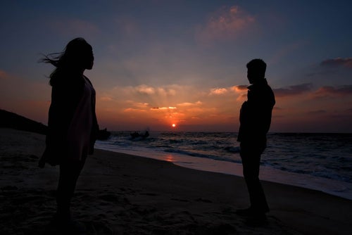 夕暮れの海辺と男女の写真