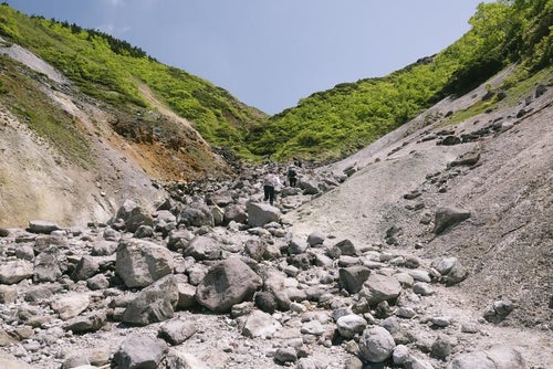 八甲田山地獄谷と登山者の写真