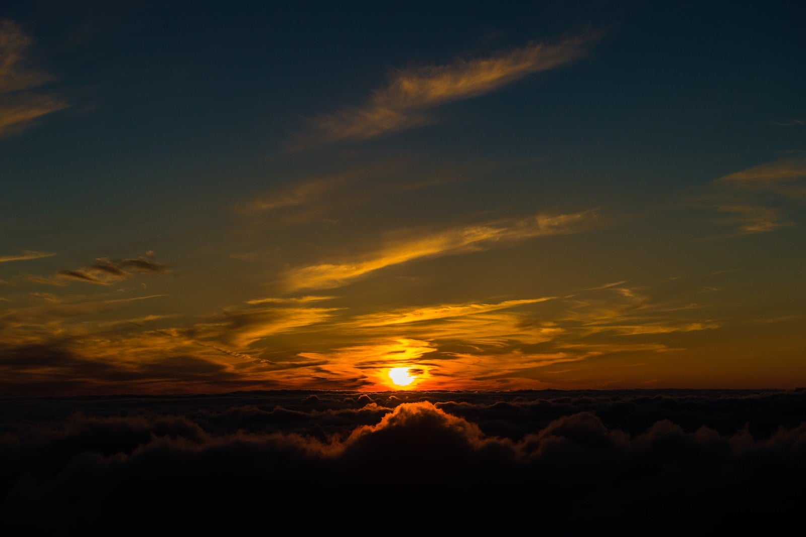 「北アルプス日没直前に煌々と光を放つ太陽」の写真