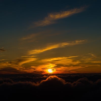 北アルプス日没直前に煌々と光を放つ太陽の写真