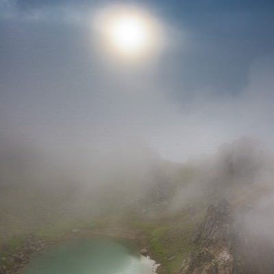 霧の中の焼岳の正賀池と日暈の写真
