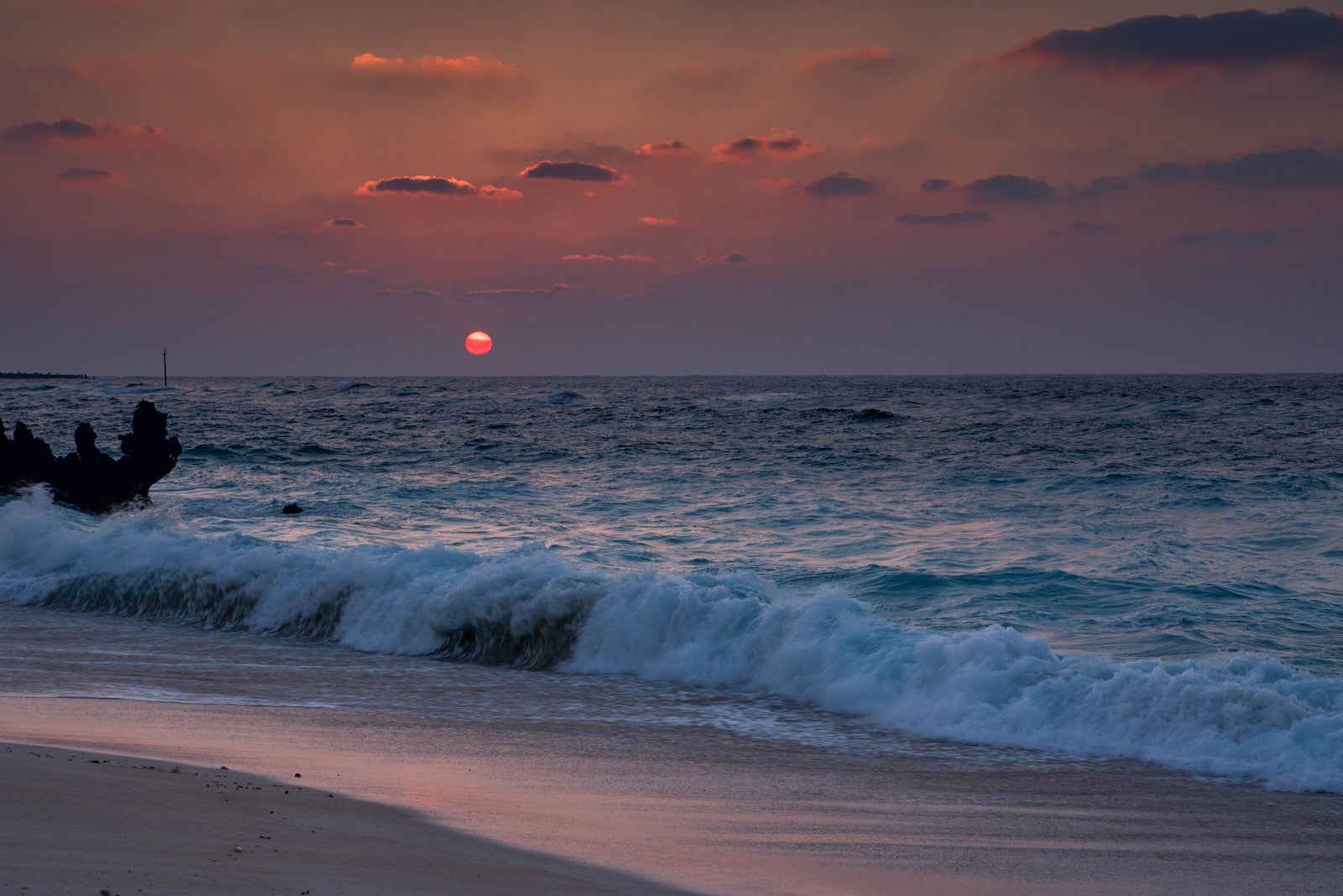 「夕焼けと与論島の海と砂浜」の写真