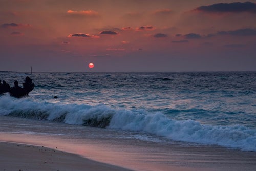 夕焼けと与論島の海と砂浜の写真
