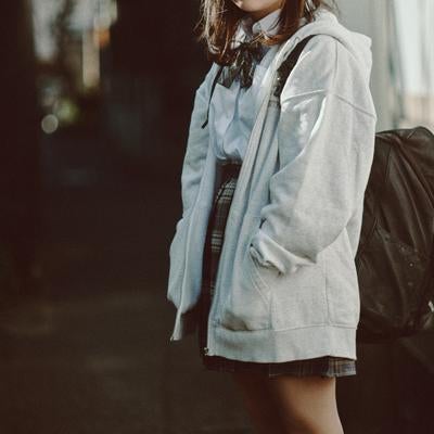 放課後の下校途中に立ち止まる女子高生の写真