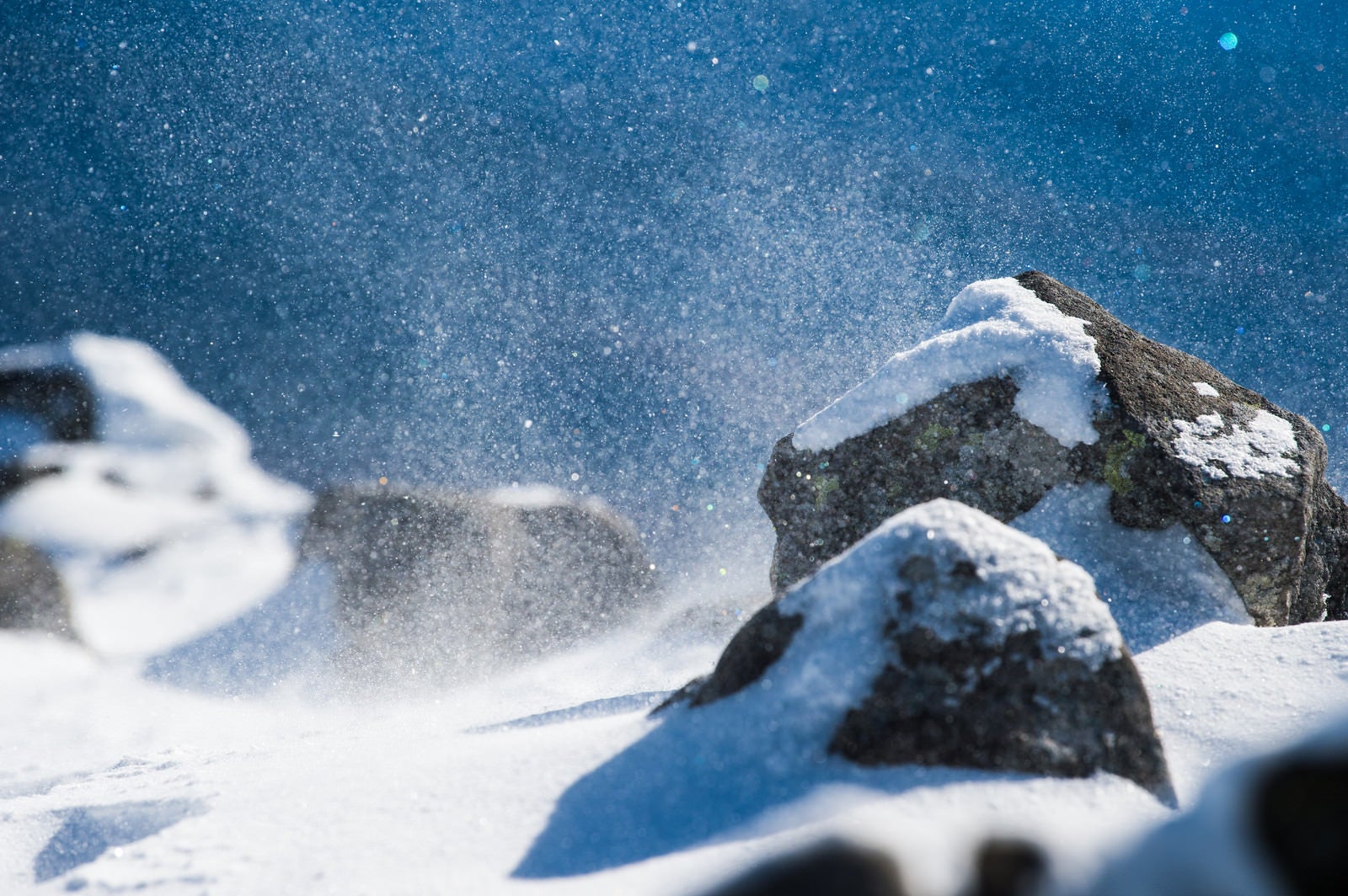 「厳冬期の山で舞い上がる雪の粒子」の写真