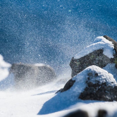 厳冬期の山で舞い上がる雪の粒子の写真