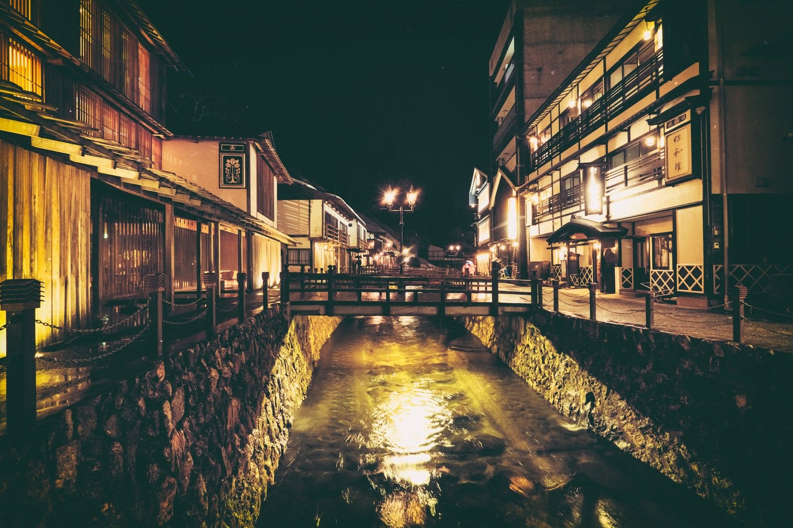 「銀山温泉街と中央に流れる銀山川（夜間）」の写真