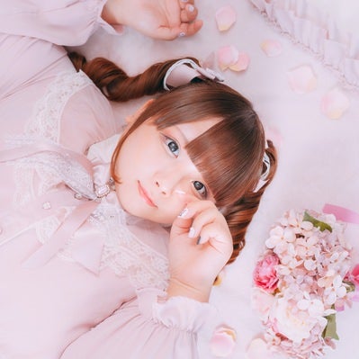 ピンクのドレスで横たわるゆるふわぽっちゃり女子の写真