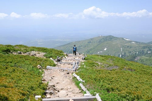 八甲田山山頂からロープウェイ方面へと下山する人の写真