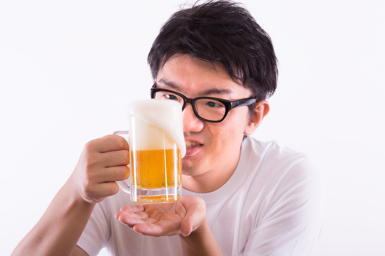「泡が溢れる生ビール」の写真［モデル：OZPA］