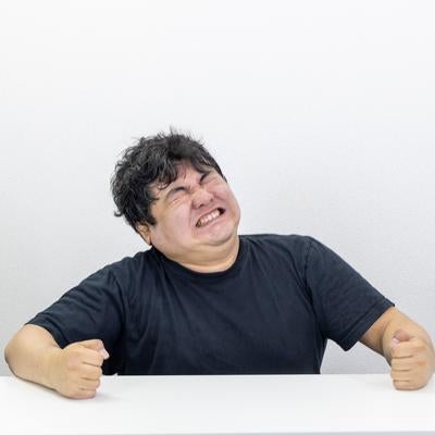 無念の表情で歯を食いしばるの写真