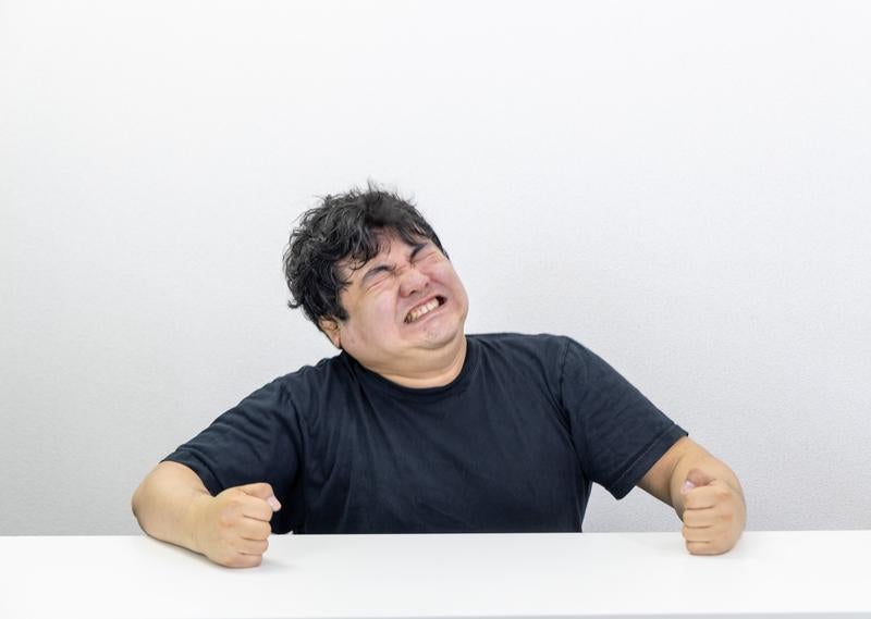 無念の表情で歯を食いしばるの写真