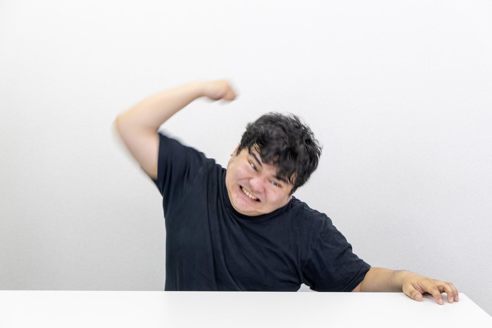「拳を振り上げる男性の迫力ある瞬間」の写真