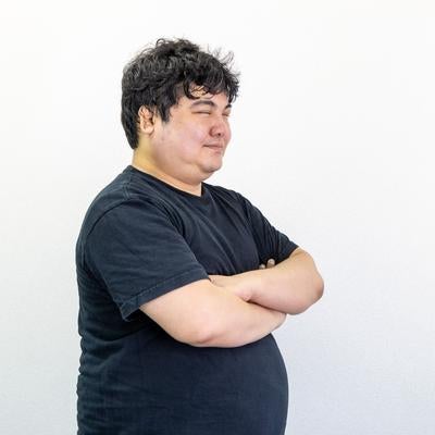 腕を組んで微笑む男性の写真