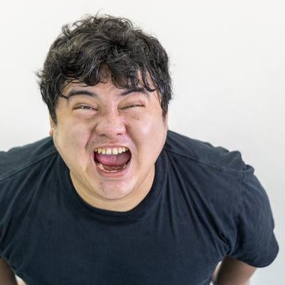 こちらを向いて叫ぶ男性の写真