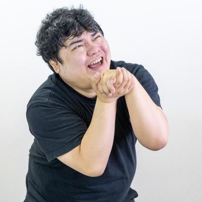 男性が両手を握り媚びへつらう様子の写真