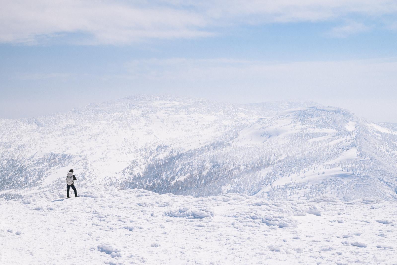 「屏風岳方面の樹氷林を眺める登山者」の写真
