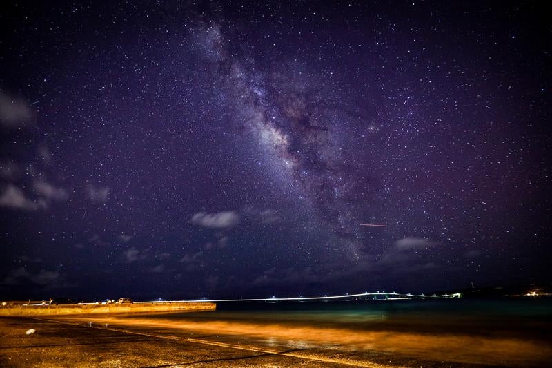 海辺の堤防から見上げる天の川と満天の星空