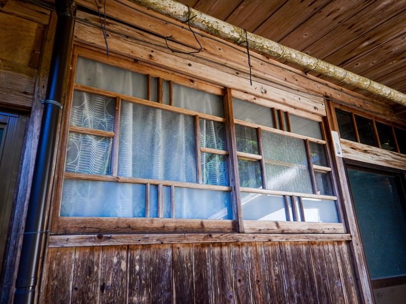 廃屋の軒下にある窓の写真