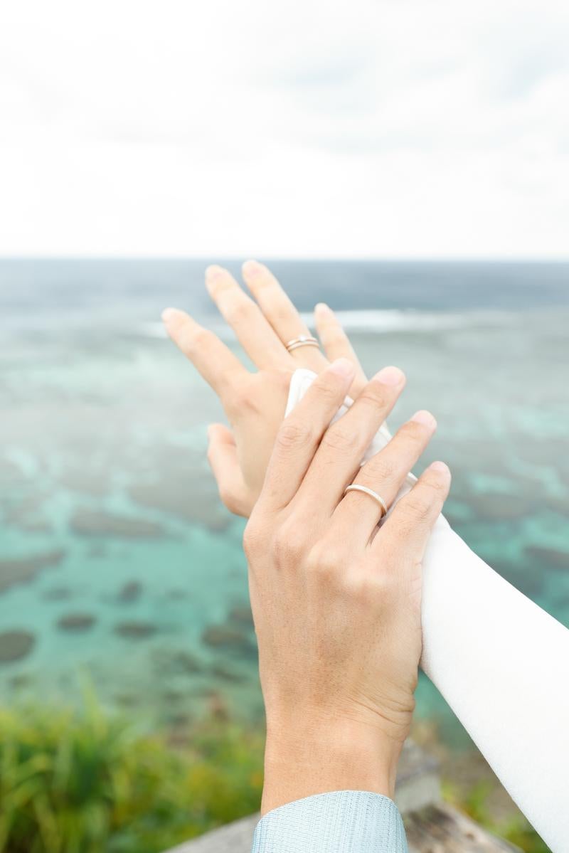 Hands Overlapped with Pair Rings Against the Sea