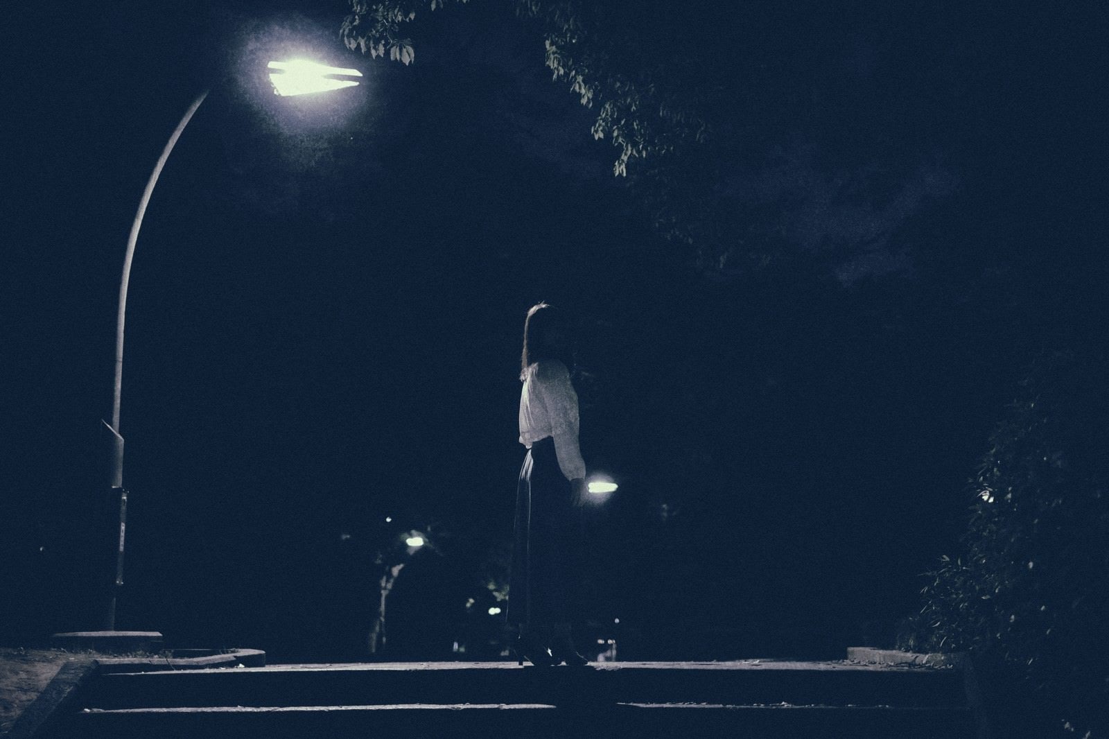 「深夜の街灯のあかりと女性」の写真