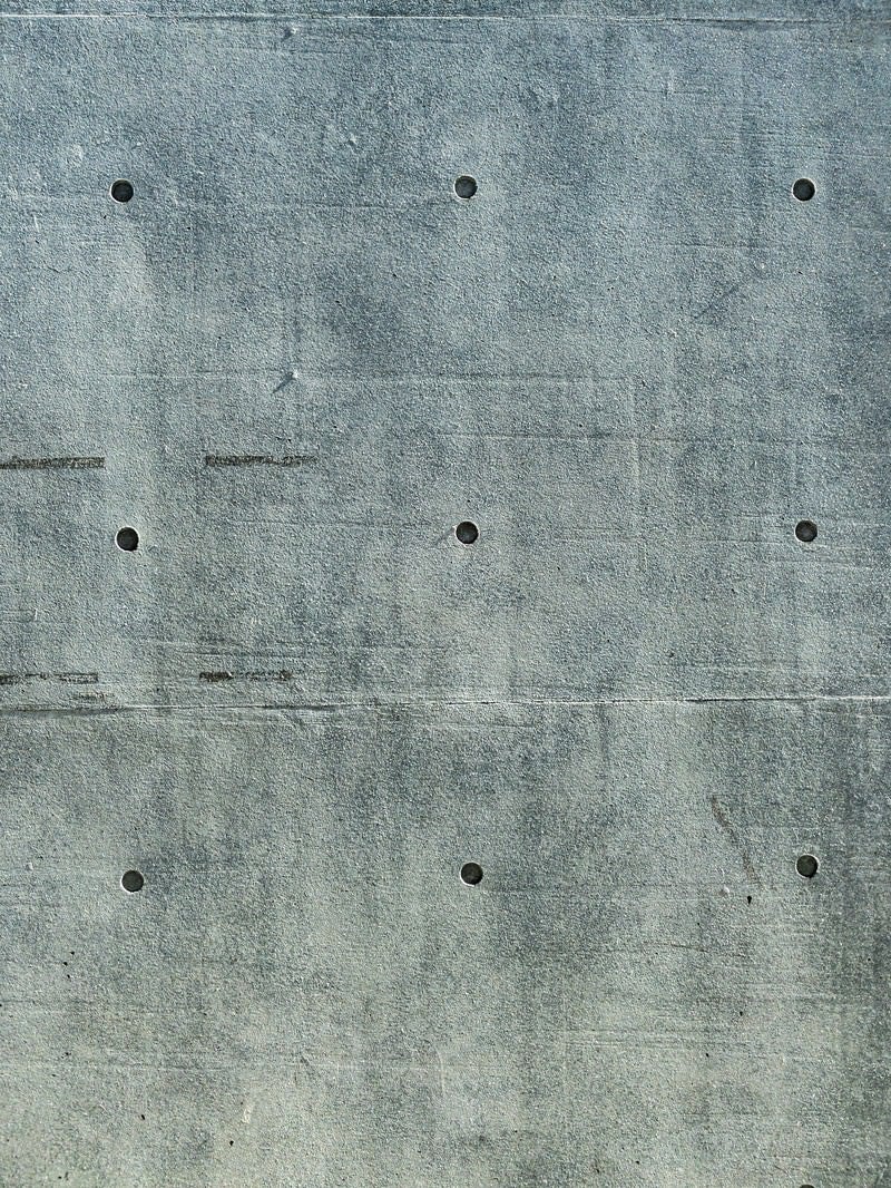 「深めのセパ穴が残るコンクリート壁」の写真