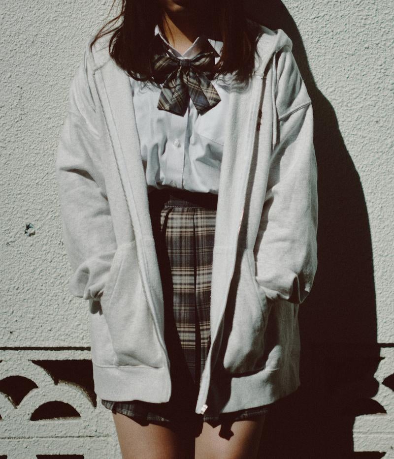 「ブロック塀によりかかる女子高生」の写真